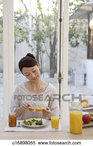 View of a young woman having breakfast View Large Photo Image Stock Photography - View of a young woman having breakfast. Fotosearch