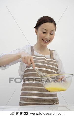 View of a young woman stirring egg yolk View Large Photo Image Stock Image - View of a young woman stirring egg yolk. Fotosearch