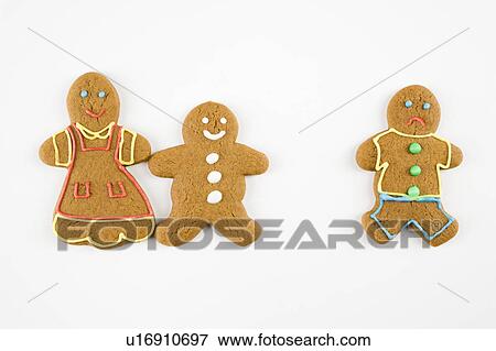 Stock Photo - Frowning male gingerbread cookie standing separate from happy gingerbread cookies holding hands.. Fotosearch