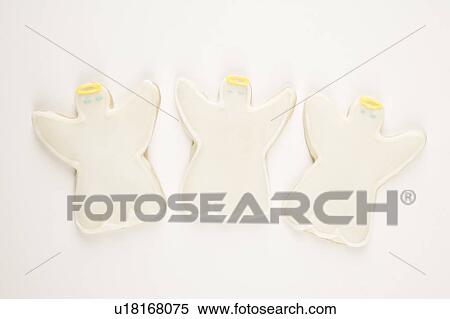 Stock Photography - Three angel sugar cookies with decorative icing.. Fotosearch