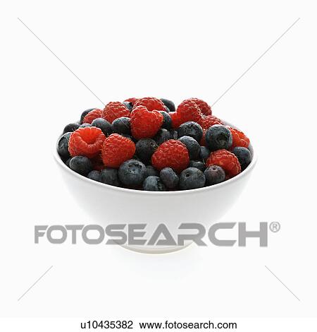 Stock Image - Bowl of mixed blueberries and raspberries on white background.. Fotosearch