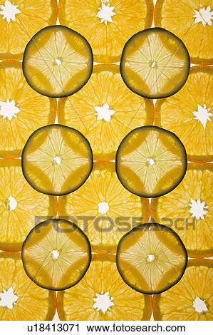 Stock Image - Orange and lime slices arranged in design on white background.. Fotosearch