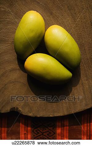 Stock Photo - Still life of three wooden mangoes on plate.. Fotosearch