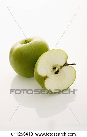 Stock Photo - Still life of whole and sliced green apples on white background.. Fotosearch