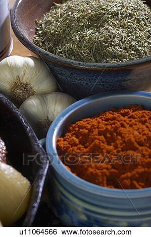Stock Photograph - Bowls of paprika and Italian seasoning with whole garlic. Fotosearch
