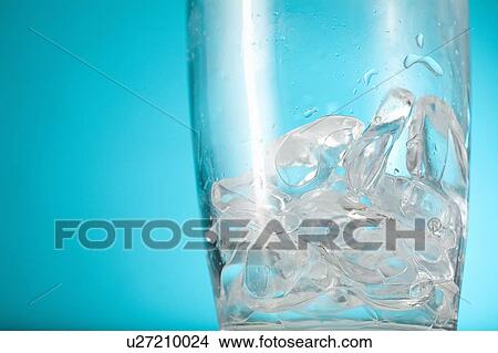 Picture - Ice chips in bottom of clear glass. Fotosearch