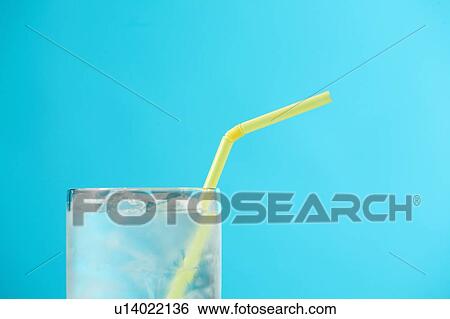 Stock Photograph - Top portion of very full glass of water with yellow drinking straw. Fotosearch