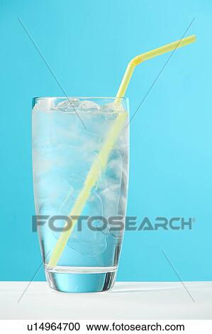 Stock Image - Very full glass of water with ice and yellow drinking straw. Fotosearch