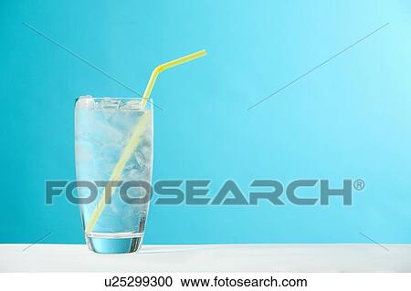 Stock Image - Very full glass of water with ice and yellow drinking straw. Fotosearch