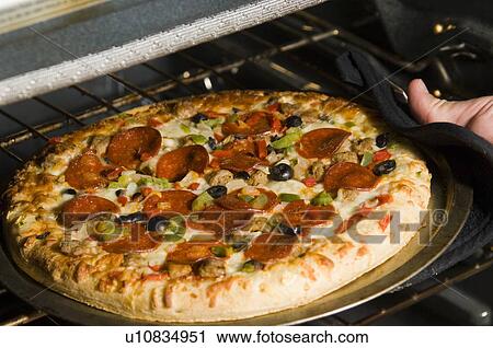 Man taking pizza out of oven View Large Photo Image Stock Image - Man taking pizza out of oven. Fotosearch