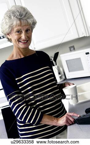 Senior woman checking answering machine View Large Photo Image Stock Photo - Senior woman checking answering machine. Fotosearch