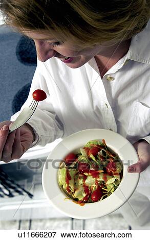 Stock Photo - Woman eating a salad. Fotosearch