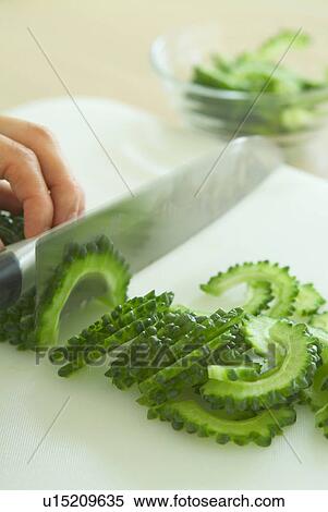 Stock Photography - A woman slicing vegetables. Fotosearch