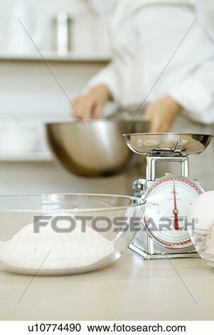 Stock Image - Bowl of flour and weight scale. Fotosearch