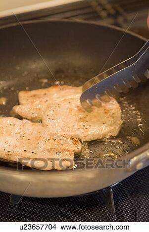 Picture - Cooking pork steaks. Fotosearch