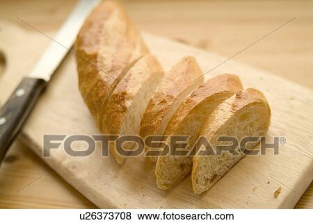Stock Photo - Cut bread on cutting board. Fotosearch