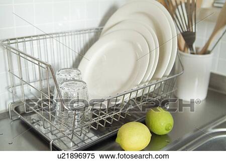 Stock Photography - Plates and glasses in dish rack. Fotosearch