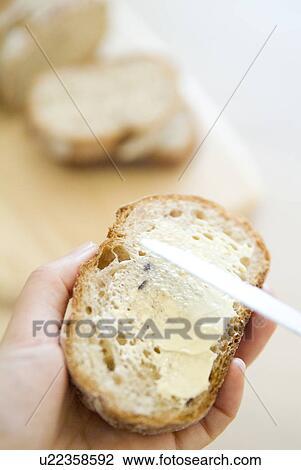 Stock Image - Spreading butter on bread. Fotosearch