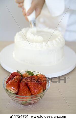 A woman decorating a cake with whipped cream View Large Photo Image Stock Image - A woman decorating a cake with whipped cream. Fotosearch