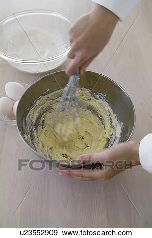 Stock Photo - A woman mixing flour and egg. Fotosearch