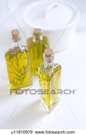 Stock Photo - Bottles of olive oil with herbs. Fotosearch