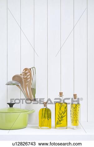 Stock Image - Kitchen utensils and bottles of olive oil with herbs. Fotosearch