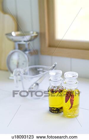 Stock Image - Kitchen utensils and bottles of olive oil with spices. Fotosearch