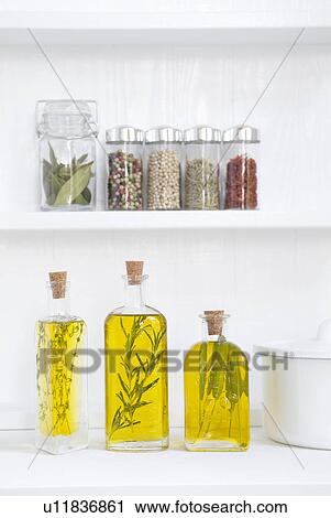 Stock Image - Spice jars and bottles of olive oil with herbs. Fotosearch