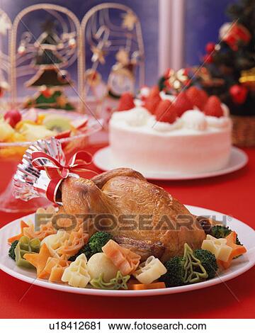 Stock Image - Roast chicken and strawberry cake served on table. Fotosearch