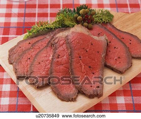 Stock Photo - Slices of roast beef on board, close-up. Fotosearch