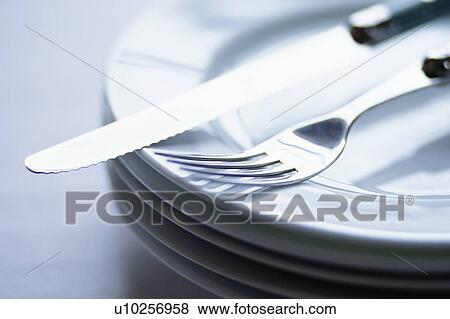 Stock Photo - Cutlery on plate, close-up. Fotosearch