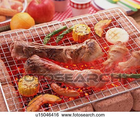 Stock Photograph - Grilled spareribs over charcoal. Fotosearch