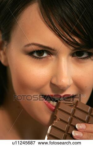 Young woman eating bar of chocolate, portrait, close up View Large Photo Image Stock Photo - Young woman eating bar of chocolate, portrait, close up. Fotosearch