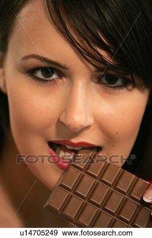 Young woman eating bar of chocolate, portrait, close up View Large Photo Image Stock Photo - Young woman eating bar of chocolate, portrait, close up. Fotosearch