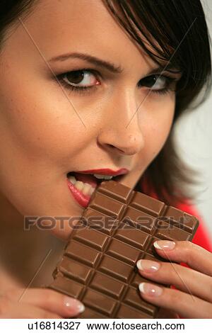 Young woman eating bar of chocolate, portrait, close up View Large Photo Image Stock Photo - Young woman eating bar of chocolate, portrait, close up. Fotosearch