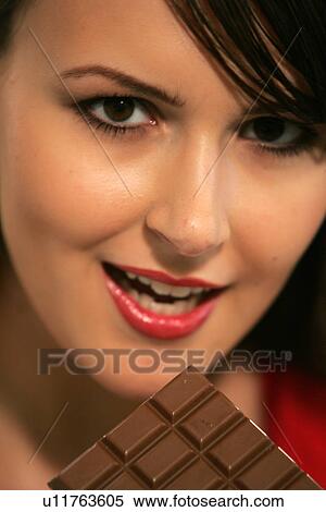 Young woman eating bar of chocolate, portrait, close up View Large Photo Image Stock Photography - Young woman eating bar of chocolate, portrait, close up. Fotosearch