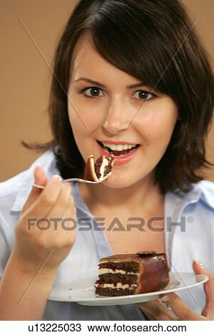 Young woman eating slice of chocolate cake, portrait, close up View Large Photo Image Stock Image - Young woman eating slice of chocolate cake, portrait, close up. Fotosearch