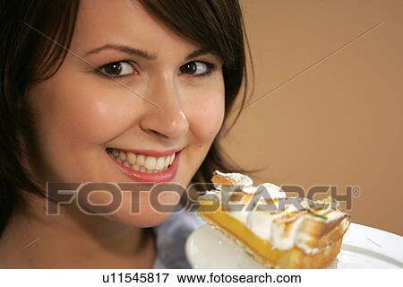Young woman eating slice of fruit pie, portrait, close up View Large Photo Image Stock Photo - Young woman eating slice of fruit pie, portrait, close up. Fotosearch