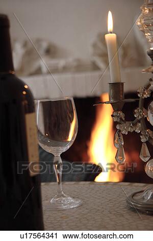 Bottle and glass of wine on a table in front of the fireplace, stillife View Large Photo Image Stock Image - Bottle and glass of wine on a table in front of the fireplace, stillife. Fotosearch