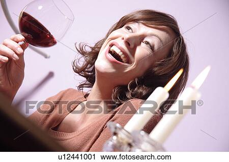 Woman holding glass of red wine, laughing View Large Photo Image Stock Image - Woman holding glass of red wine, laughing. Fotosearch