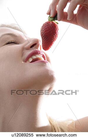 Young blond woman about to eat strawberry, close up View Large Photo Image Stock Photography - Young blond woman about to eat strawberry, close up. Fotosearch