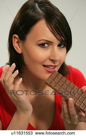 Young woman eating bar of chocolate, portrait, close up View Large Photo Image Stock Image - Young woman eating bar of chocolate, portrait, close up. Fotosearch