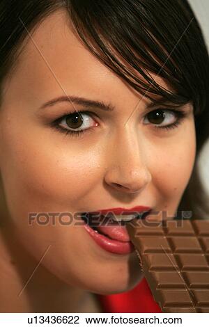 Young woman eating bar of chocolate, portrait, close up View Large Photo Image Stock Image - Young woman eating bar of chocolate, portrait, close up. Fotosearch