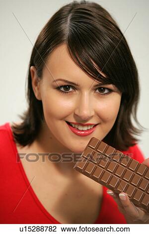 Young woman eating bar of chocolate, portrait, close up View Large Photo Image Stock Image - Young woman eating bar of chocolate, portrait, close up. Fotosearch