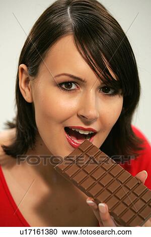 Young woman eating bar of chocolate, portrait, close up View Large Photo Image Stock Image - Young woman eating bar of chocolate, portrait, close up. Fotosearch