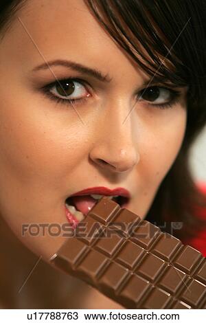 Young woman eating bar of chocolate, portrait, close up View Large Photo Image Stock Image - Young woman eating bar of chocolate, portrait, close up. Fotosearch