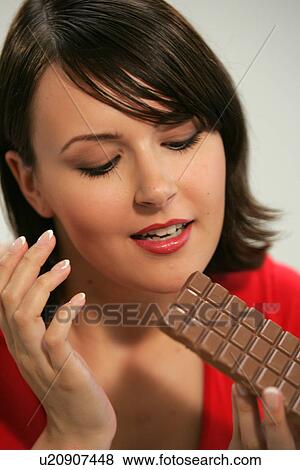 Young woman eating bar of chocolate, portrait, close up View Large Photo Image Stock Photo - Young woman eating bar of chocolate, portrait, close up. Fotosearch