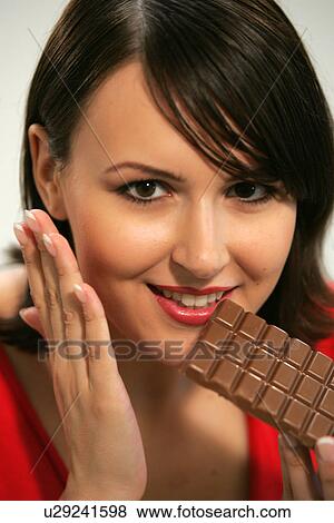 Young woman eating bar of chocolate, portrait, close up View Large Photo Image Stock Photo - Young woman eating bar of chocolate, portrait, close up. Fotosearch