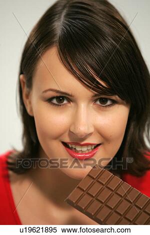 Young woman eating bar of chocolate, portrait, close up View Large Photo Image Stock Photography - Young woman eating bar of chocolate, portrait, close up. Fotosearch