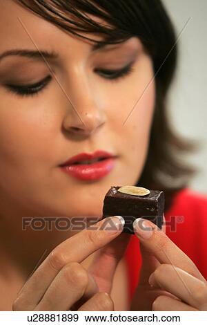 Young woman eating chocolate candy, portrait, close up View Large Photo Image Stock Photo - Young woman eating chocolate candy, portrait, close up. Fotosearch